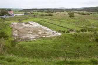 View.  Concrete base of Cordite loading station with platform and course of tramway to right, from SW.