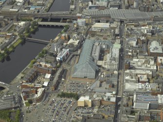 Oblique aerial view centred on the shopping centre with the station adjacent, taken from the E.