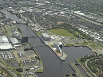 General oblique aerial view of the city looking along the river across the science centre and exhibition centre, taken from the NW.