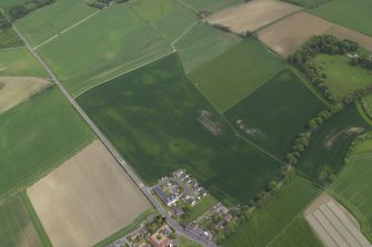 Oblique aerial view centred on the cropmarks of the possible henge, possible barrow and rig with the brewery adjacent, taken from the W.