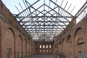 Interior. Heavy machine shop (former erecting shop) from E showing N brick aisle wall and extent of dismantling in advance of conversion