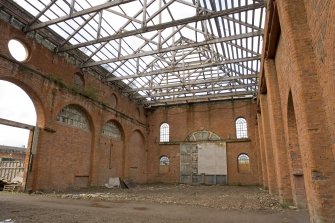 Interior. View of light machine shop (former boiler shop) from NE. Original wooden door and arched window arrangment visible