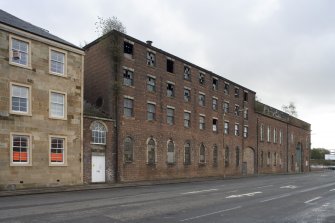 View of West Street elevation showing boiler house with fanlight (c.1855) and original pattern making department on the ground floor, pattern stores on floors above of the 9 bay brick building with the later blocked archway entrance