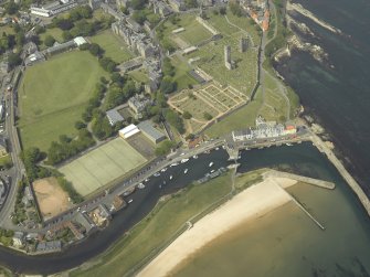 Oblique aerial view of St Andrews centred on the harbour with the cathedral and school adjacent, taken from the ESE.
