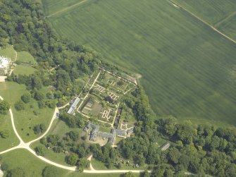 Oblique aerial view centred on the walled garden and the stables, taken from the W.