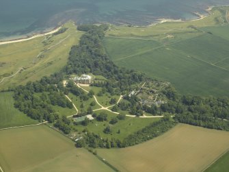 General oblique aerial view centred on the country house, walled gardens and stables, taken from the WSW.