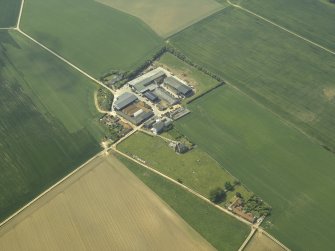 Oblique aerial view centred on the farmhouse and the farmsteading, taken from the ENE.