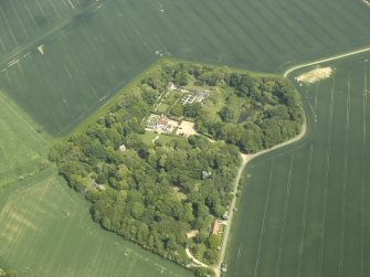 General oblique aerial view centred on the country house, stable block, dovecot and walled garden, taken from the SW.