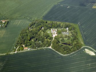 General oblique aerial view centred on the country house, stable block, dovecot and walled garden, taken from the S.