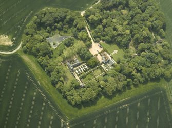 Oblique aerial view centred on the country house, stable block, dovecot and walled garden, taken from the NNE.