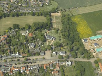 Oblique aerial view centred on the church, churchyard and burial ground with the hotel adjacent, taken from the SE.