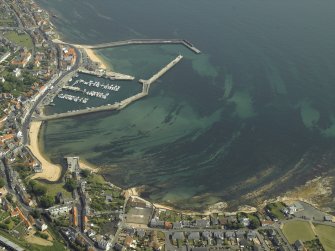 General oblique aerial view of the village centred on the harbour, taken from the W.