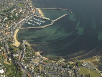 General oblique aerial view of the village centred on the harbour, taken from the WSW.