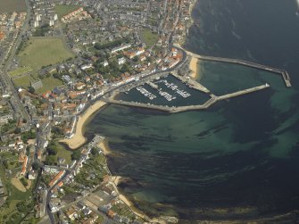 General oblique aerial view of the village centred on the harbour, taken from the SW.