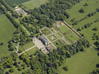 Oblique aerial view centred on the country house, garden and stable with the cottage, farmsteading and stable adjacent, taken from the W.