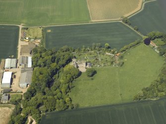 Oblique aerial view centred on the remains of the castle, stable and walled garden, taken from the SSE.