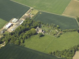 Oblique aerial view centred on the remains of the castle, stable and walled garden, taken from the SE.