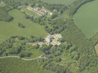 General oblique aerial view centred on the country house with the farmstead, walled garden, cottages, sawmill and dovecot adjacent, taken from the SE.