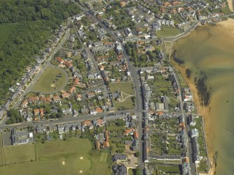 General oblique aerial view of the village centred on the church, churchyard and burial ground, taken from the WNW.