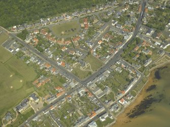 General oblique aerial view of the village centred on the church, churchyard and burial ground, taken from the WSW.