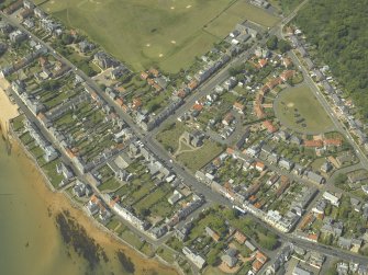 General oblique aerial view of the village centred on the church, churchyard and burial ground, taken from the SE.