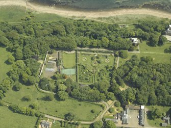 Oblique aerial view centred on the walled garden and orangery with the stables and cottage adjacent, taken from the WNW.