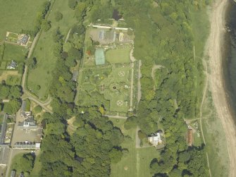 Oblique aerial view centred on the walled garden and orangery with the stables and cottages adjacent, taken from the SSW.