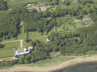 Oblique aerial view centred on the tower-house and walled garden with the stables adjacent, taken from the SE.