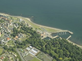 General oblique aerial view centred on the harbour with the monastery, garden, church, churchyard and burial ground adjacent, taken from the W.