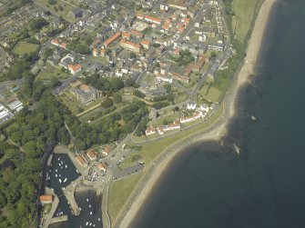 Oblique aerial view centred on the house, monastery and gardens with the church, burial ground and harbour adjacent, taken from the SSW.