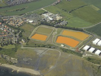 Oblique aerial view centred on the settling ponds, taken from the SE.