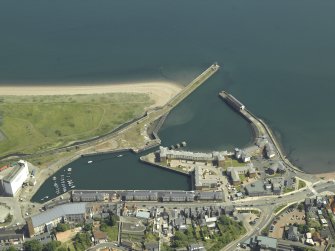Oblique aerial view centred on the harbour and dock, taken from the WNW.