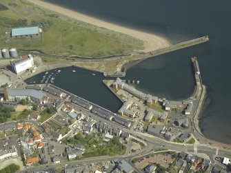 Oblique aerial view centred on the harbour and dock, taken from the W.