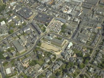 General oblique aerial view centred on the clock tower and town house with the church adjacent, taken from the W.