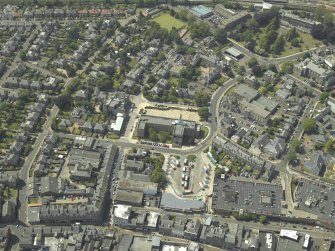 General oblique aerial view centred on the clock tower and town house with the church adjacent, taken from the ESE.