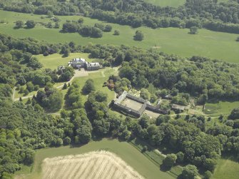 Oblique aerial view centred on the country house and stable block, taken from the NNW.