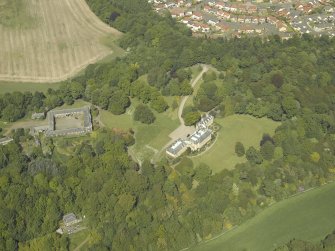 Oblique aerial view centred on the country house and stable block, taken from the SW.