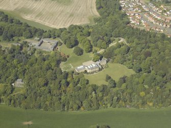 Oblique aerial view centred on the country house and stable block, taken from the S.