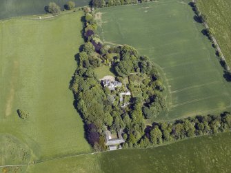 Oblique aerial view centred on the country house, conservatory, dovecot and farmsteading, taken from the WSW.