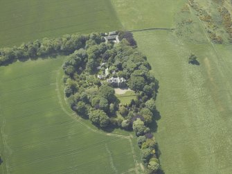 Oblique aerial view centred on the country house, conservatory, dovecot and farmsteading, taken from the E.