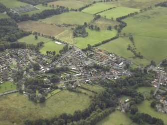 Oblique aerial view centred on part of Saline village including Oakley Road, the parish church, primary school  and old graveyard from the NE.
