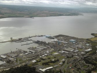 General oblique aerial view centred on the naval dockyard with the remains of the tower-house in the foreground, taken from the NE.