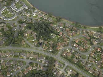 Oblique aerial view of the town centred on the remains of the chapel with the house adjacent, taken from the WNW.