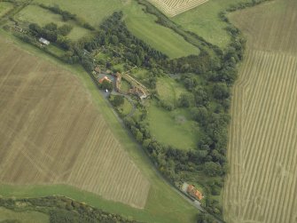 Oblique aerial view centred on the country house, cottage and walled garden, taken from the NW.