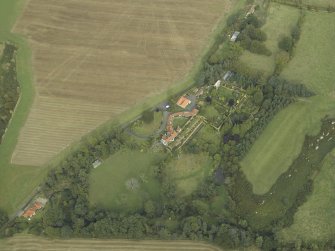 Oblique aerial view centred on the country house, cottage and walled garden, taken from the SW.