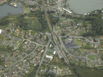 Oblique aerial view of the village centred on the railway station and school, taken from the N.