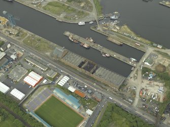 Oblique aerial view centred on the burnt out sugar warehouse and the docks, taken from the S.