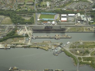 Oblique aerial view centred on the burnt out sugar warehouse and the docks, taken from the NNE.