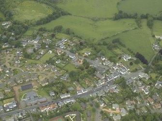 General oblique aerial view of the village centred on the churches, burial-ground and manse, taken from the S.