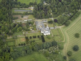 Oblique aerial view centred on the country house, walled garden, gardens and terraces, taken from the SSW.